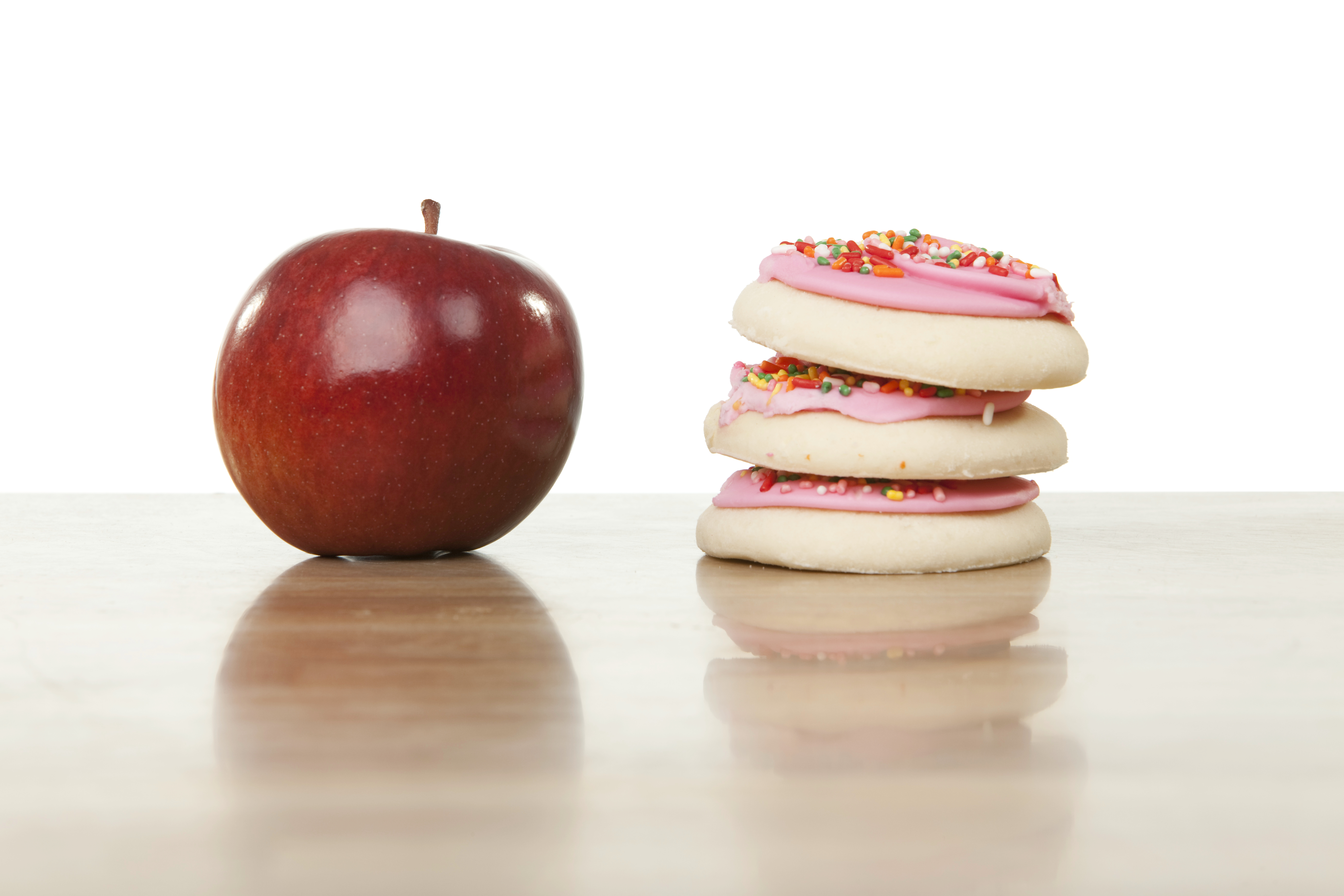 an apple and a stack of sugar cookies