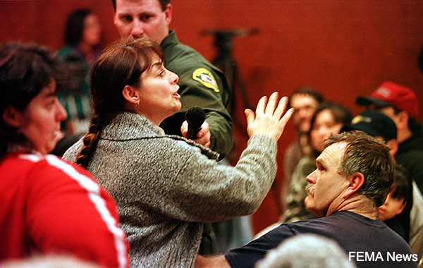 A hostile woman being escorted from a meeting