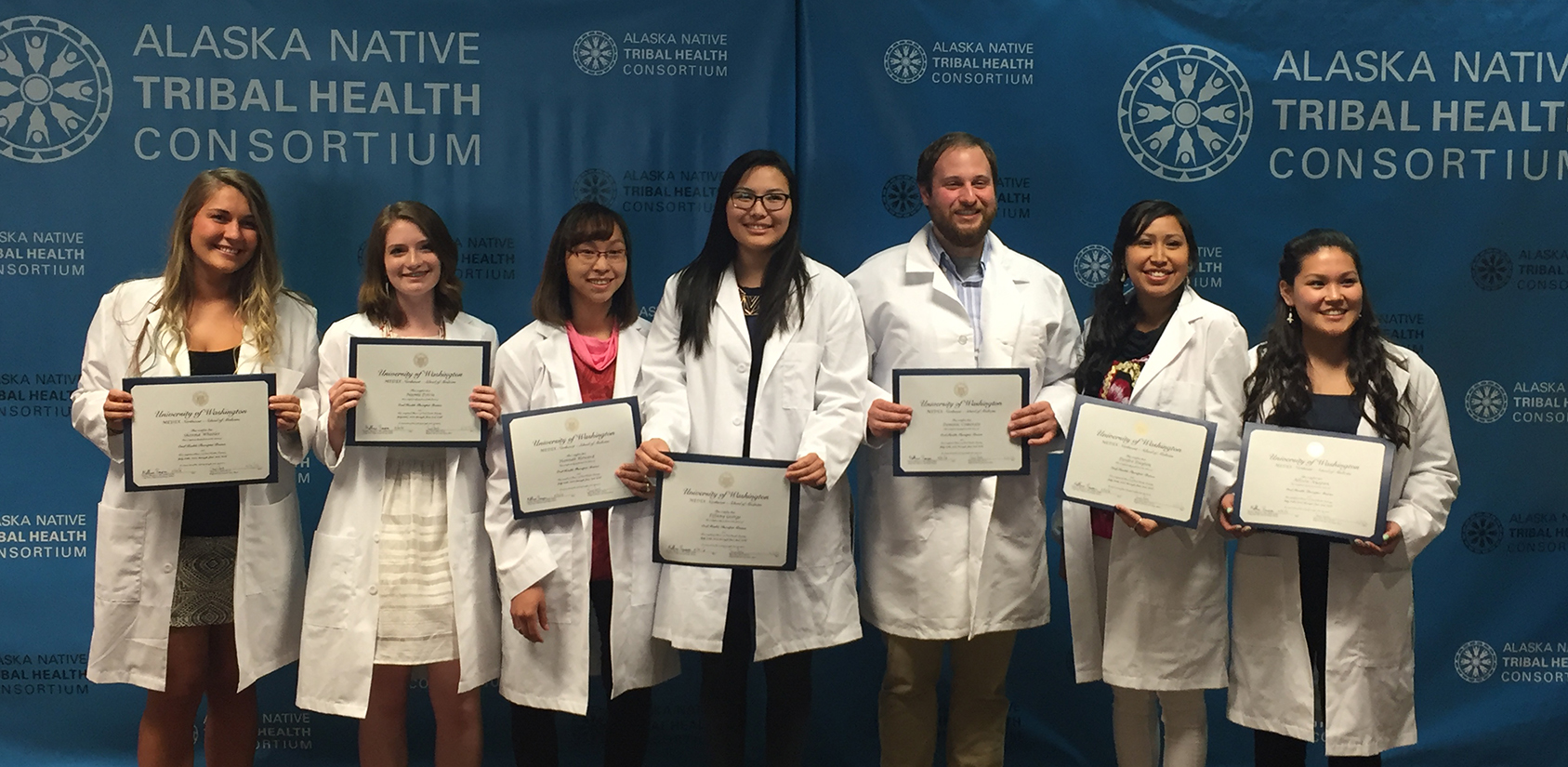 Graduates holding diplomas