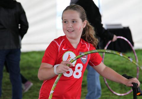 Photograph of a girl using a hula hoop wearing the Sqord bracelet.