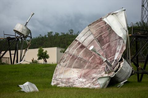 Photograph of a satellite dish that has been destroyed by high winds.