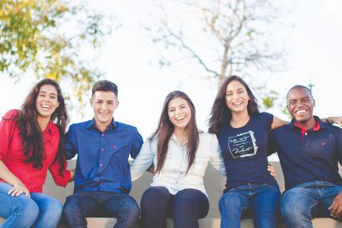 Photograph of several young adults seated in a line.