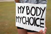 A woman holds a protest sign that reads "MY BODY MY CHOICE"