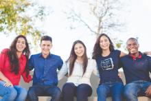 Photograph of several young adults seated in a line.