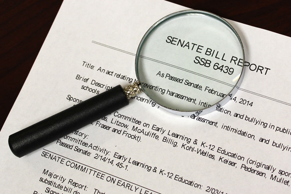 Photograph of a magnifying glass over a legal document.