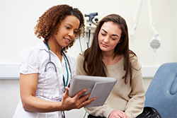 Photograph of a woman consulting with a health care provider.