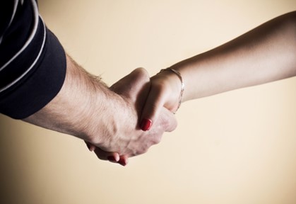 Photograph of two hands clasped in a handshake.