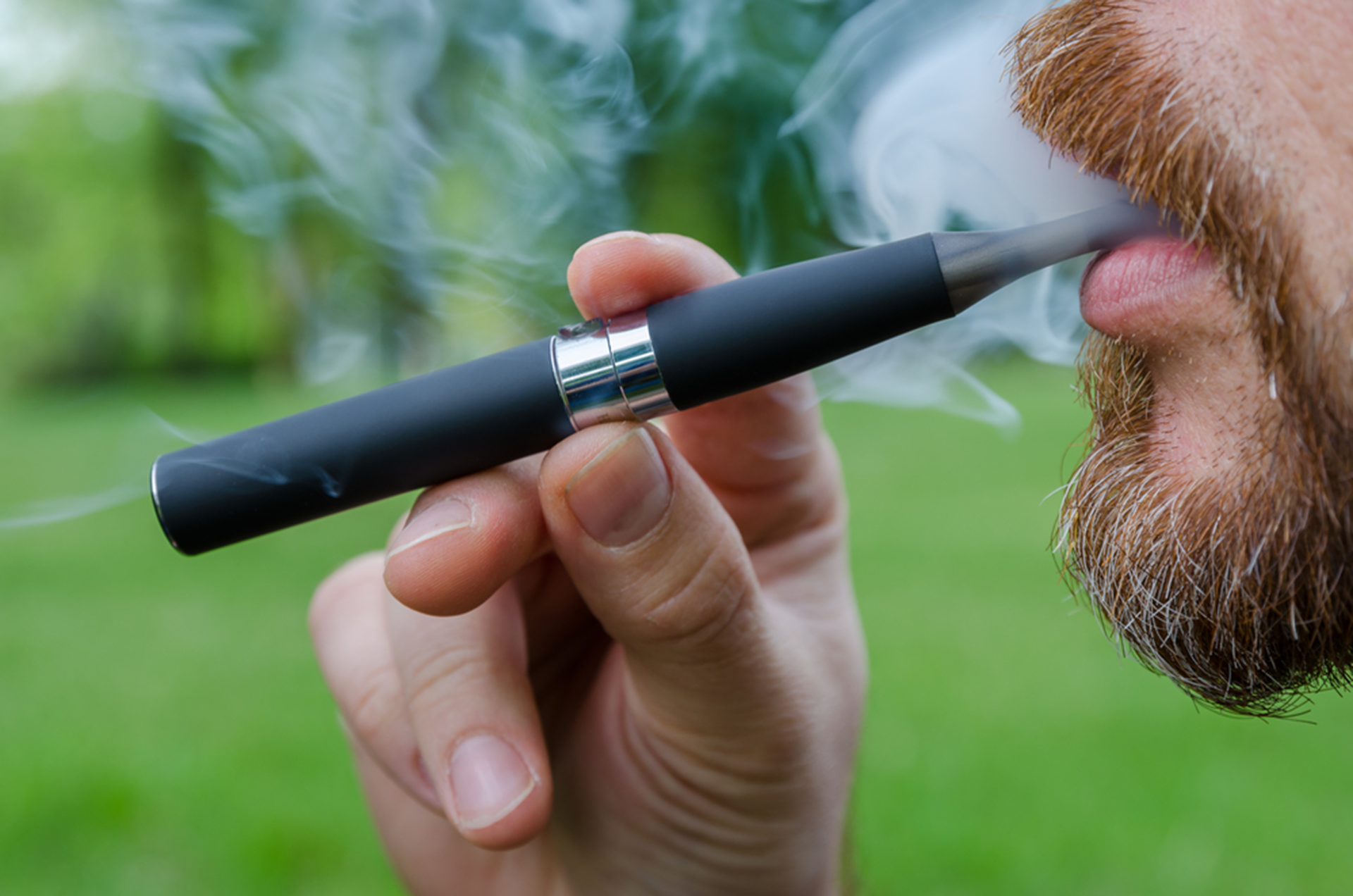 Photograph of a man using an e-cigarette.