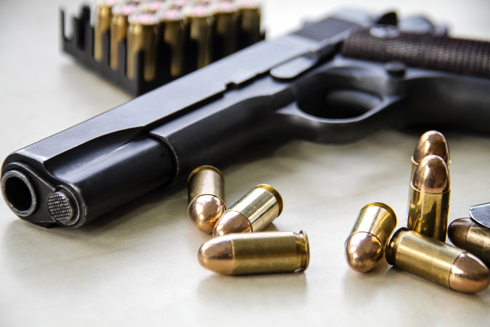 Photograph of a handgun and ammunition.